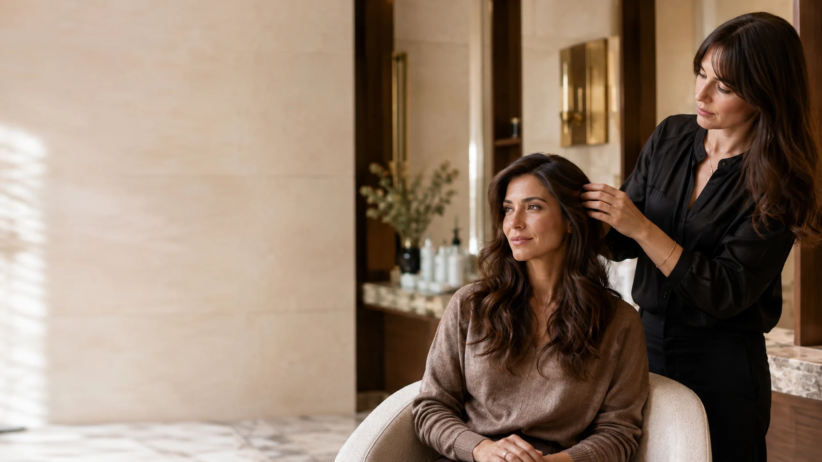 A guest receiving finishing touches in a warm, private salon setting